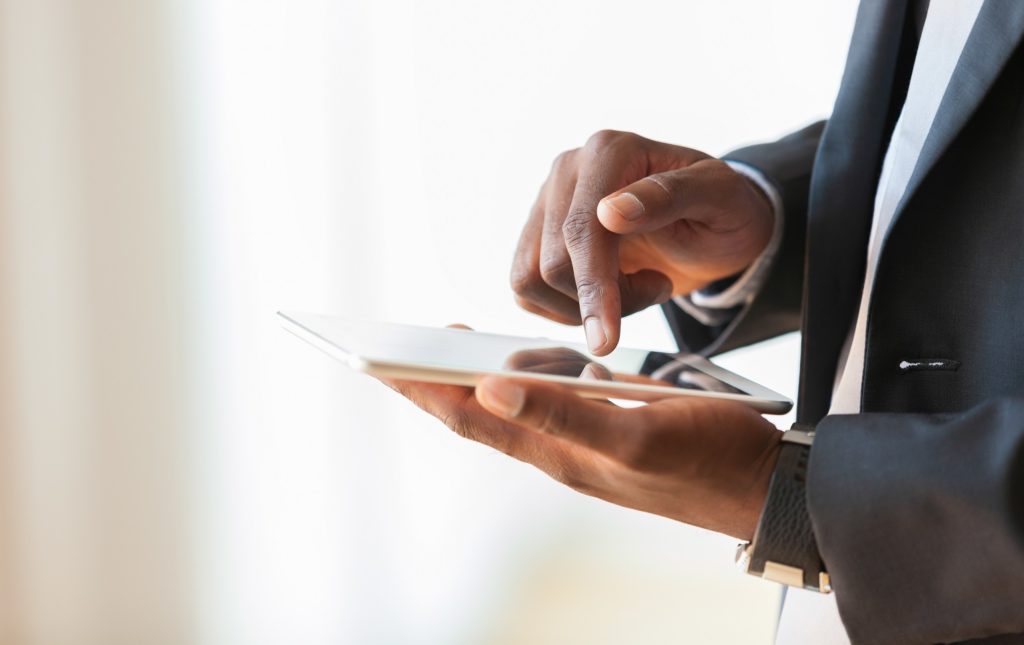 African american business man using a tactile tablet over white background - Black people